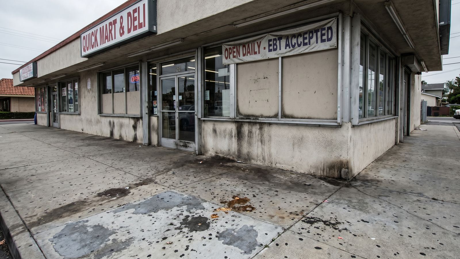 Commercial storefront with dirty sidewalk and walls before B&R pressure washing
