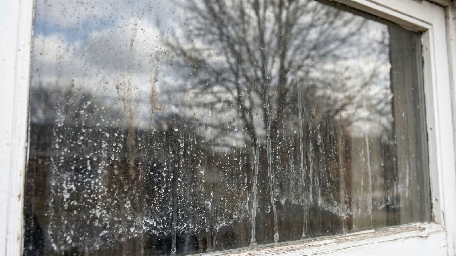Residential window with hard water stains and streaks before B&R cleaning
